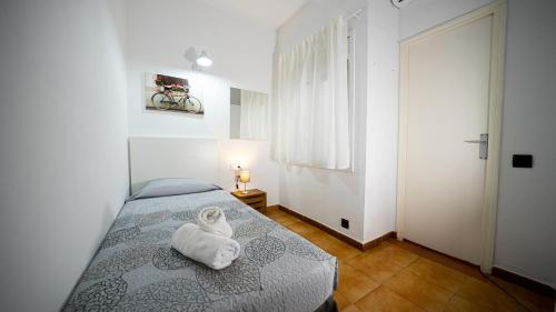 a bedroom with a bed with a towel on it at Hostal La Premsa in Arenys de Mar