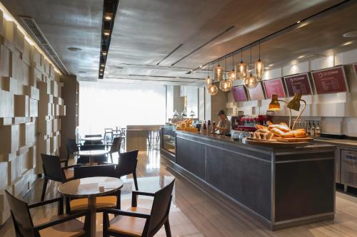a restaurant with a counter with chairs and a table at Marco Polo Ortigas Manila in Manila