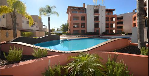 a swimming pool in the middle of a building at Vilamoura Victoria Gardens With Pool by Homing in Vilamoura