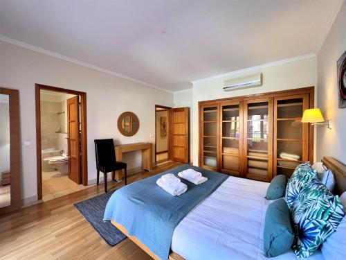 1 dormitorio con 1 cama azul grande y escritorio en Vilamoura Victoria Gardens With Pool by Homing, en Vilamoura