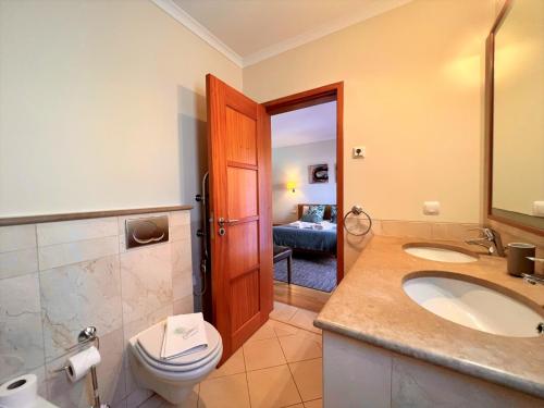 a bathroom with a toilet and a sink and a toilet istg at Vilamoura Victoria Gardens With Pool by Homing in Vilamoura