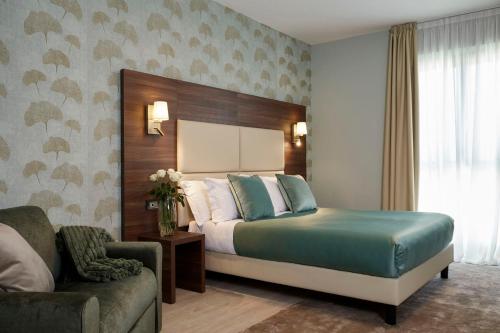 a hotel room with a bed and a couch at Hotel Spigamonti in Negrar