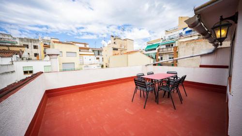 a table and chairs on the balcony of a building at Hostal La Premsa in Arenys de Mar