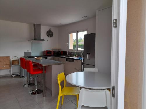 une cuisine avec une table, des chaises et une table dans l'établissement LES LANDES DU MEDOC, à Hourtin