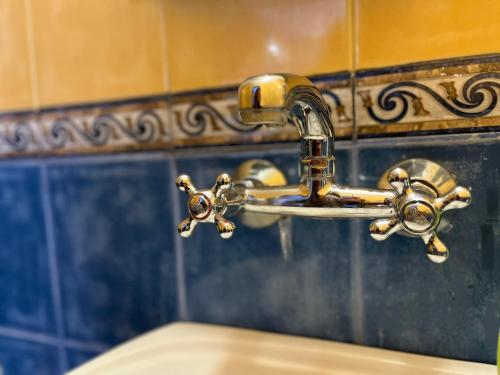 a bathroom sink with a brass water faucet at BRUNETTE BEAUTIES Guesthouse & Studio Sinemorets in Sinemorets