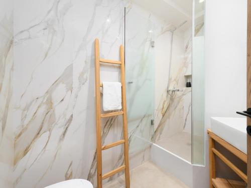 a bathroom with a white marble wall at The H Experience Boutique Apartment Downtown Heraklion in Heraklio