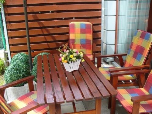 a wooden table and two chairs with flowers on a patio at Garden apartment with garage in central Prague in Prague