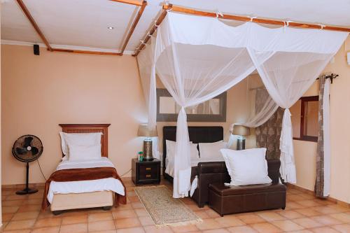 KitweにあるShamba Lodgeのベッドと天蓋付きの寝室