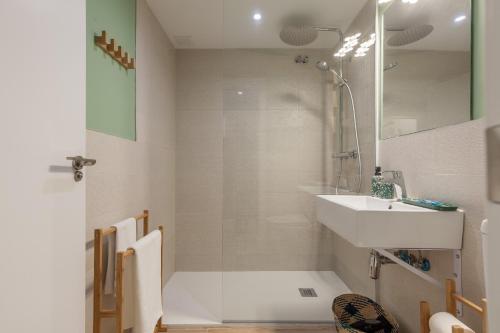 y baño blanco con lavabo y ducha. en Green-Apartments Plaza del Pan, en Sevilla