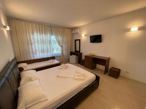 a hotel room with two beds and a television at VILA REGAL Mamaia in Mamaia