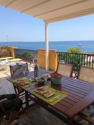 a wooden table with food on it with the ocean in the background at Sunrise B&B Le castella in Le Castella