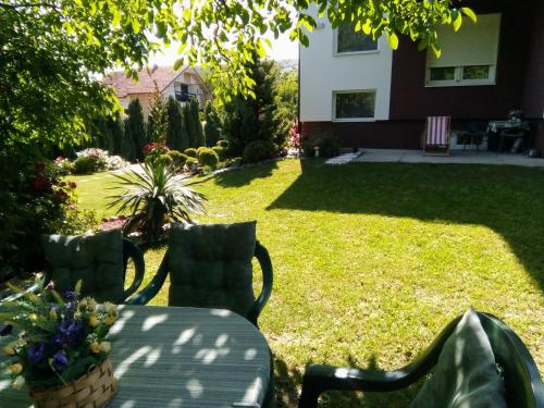 a backyard with two chairs and a table and a lawn at Apartment Vila MM Srce in Vrdnik