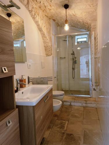 a bathroom with a sink and a shower and a toilet at Casa Nené in Cisternino