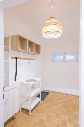 a white room with a table and a chandelier at Cozy Kunsthaus GRAZ in Graz