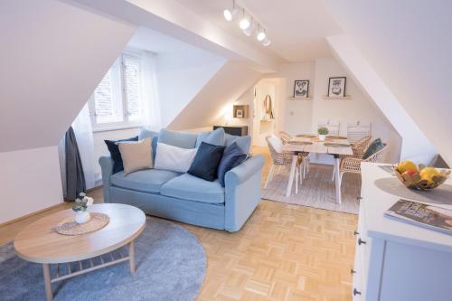 ein Wohnzimmer mit einem blauen Sofa und einem Tisch in der Unterkunft Cozy Kunsthaus GRAZ in Graz
