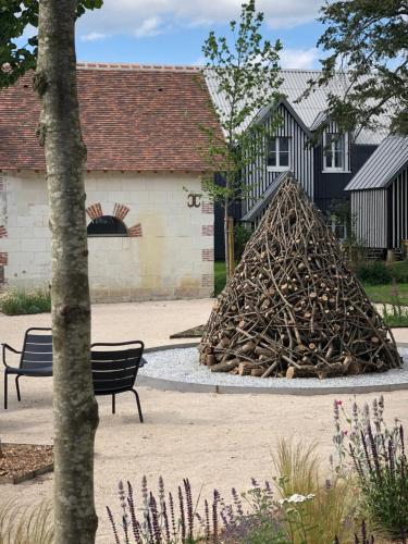 stos drewna opałowego siedzącego obok ławki w obiekcie Le Bois des Chambres w mieście Chaumont-sur-Loire
