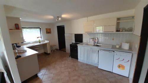 a large kitchen with white cabinets and a sink at La Prairie in Korenica