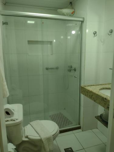 a bathroom with a shower with a toilet and a sink at Farol Barra Flat 202 in Salvador