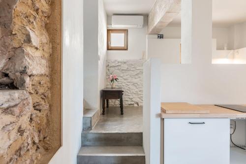 a kitchen with stairs leading up to a stone wall at La Casa Baja in Sagunto