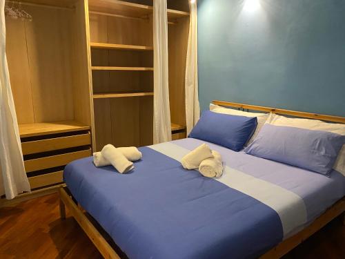 a bedroom with a blue bed with towels on it at La piccola terrazza in Bari