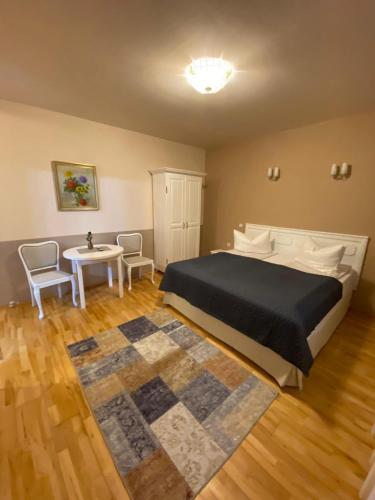 a bedroom with a bed and a table with chairs at Vila David in Baile Unu Mai