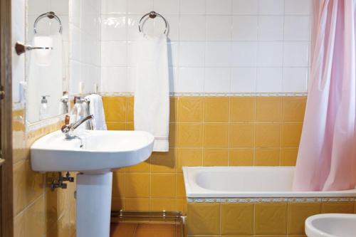 a bathroom with a sink and a bath tub at Apartamentos Casa Margot in Sevares