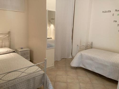 Habitación pequeña con 2 camas y espejo. en Centrale a Tropea, en Tropea