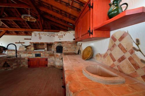 a kitchen with a stone fireplace and a sink at Hanság Vendégház in Kapuvár