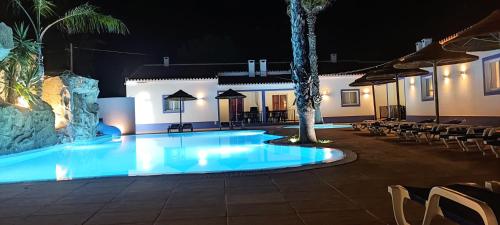 a swimming pool in front of a hotel at night at Casa Almeida in Vimieiro