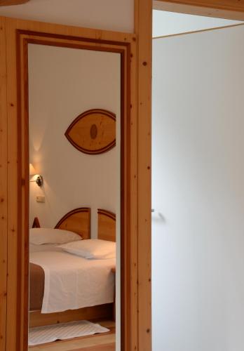 a bedroom with a bed and a mirror at Parkhotel Sole Paradiso in San Candido