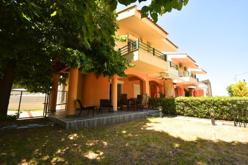 a building with chairs and tables in a yard at Nena Sea Side Maisonette, Hanioti in Hanioti