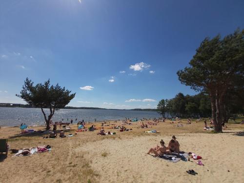 a group of people laying on a beach at Apartament GórnyŚląsk blisko jeziora - 120qm - 3 sypialnie z parkingiem i klimatyzacją - Flat UpperSilesia with Parking & air conditioning - Ferienwohnung OberSchlesien mit 3 Schlafzimmern inklusive Parkplatz und Klima - Nähe Badesee und Sandstrand in Niewiesze