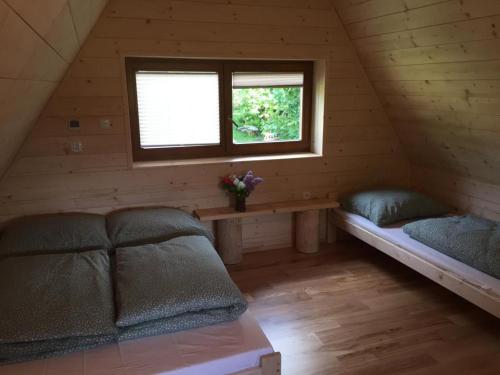 Habitación con cama y ventana en una cabaña en Chatka z sauną nad rzeką en Żabnica