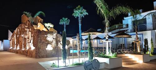 un complejo con palmeras y piscina por la noche en Casa Almeida en Vimieiro
