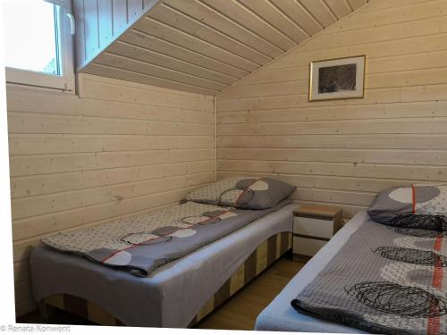 Tempat tidur dalam kamar di Domki Drewniane TREBOR