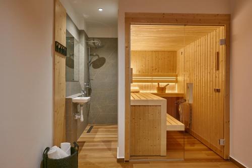 baño con paredes de madera, lavabo y espejo en Luxury Villa Mia - Sevid en Sevid