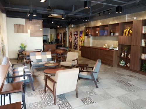 un restaurante con sillas y mesas en una habitación en Raintree Boutique Hotel, en Kajang