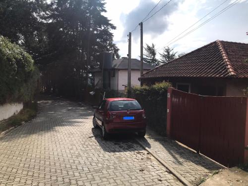 a red car parked in a driveway next to a fence at Apartamento Duda 03 in Monte Verde