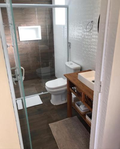a bathroom with a toilet and a sink and a shower at Apartamento Duda 03 in Monte Verde