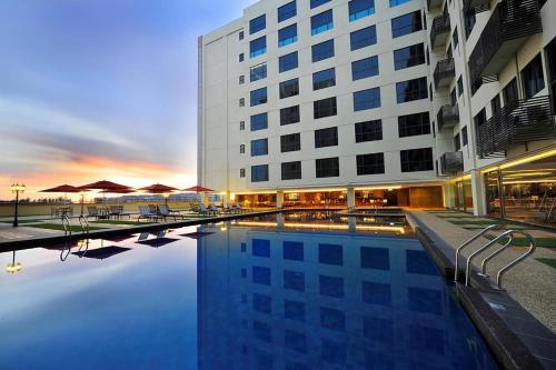 um hotel com piscina em frente a um edifício em Ming Garden Hotel & Residences em Kota Kinabalu