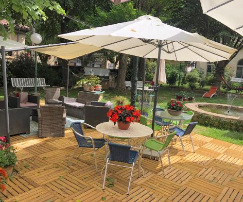 a patio with a table and chairs and an umbrella at La Vie en Roses in Rennes-les-Bains
