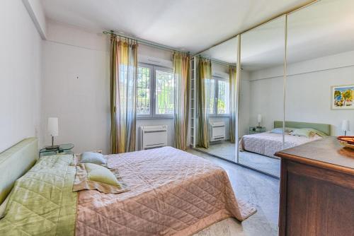 um quarto com 2 camas e um espelho grande em La Villa Roquebrune em Roquebrune-Cap-Martin