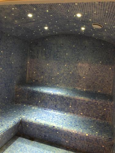 a bathroom with a blue tiled wall at La Vie en Roses in Rennes-les-Bains
