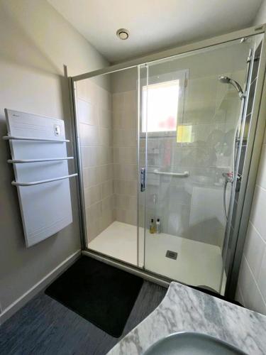 une salle de bain avec une douche en verre avec un lavabo dans l'établissement La Maison Cilaos - Proche mer, à Les Sables-dʼOlonne