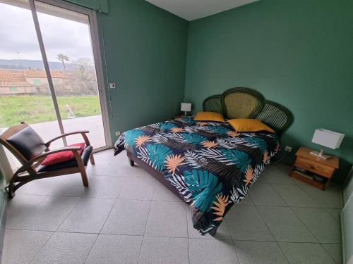 une chambre avec un lit, une chaise et une fenêtre dans l'établissement Villa de la gare, à Montbazin