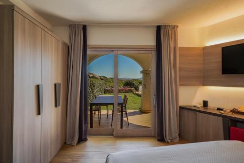 una camera da letto con una porta che conduce a un tavolo con vista di Your lovely and elegant home with garden sea view a La Maddalena