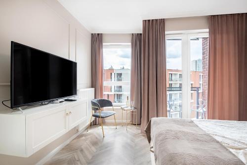 a bedroom with a flat screen tv on a white dresser at apart76 Gdańsk Bastion Wałowa in Gdańsk
