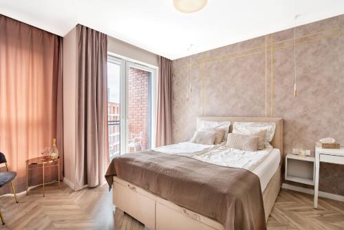 sypialnia z dużym łóżkiem i dużym oknem w obiekcie apart76 Gdańsk Bastion Wałowa w Gdańsku
