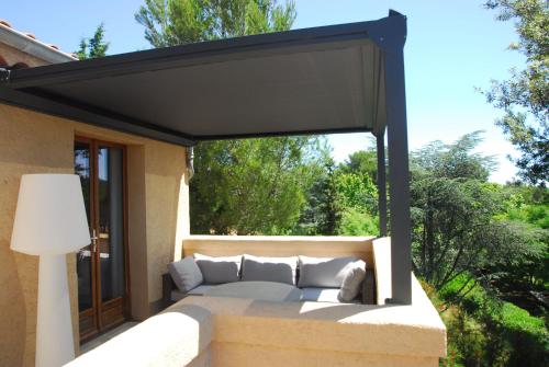 a patio with a couch under awning at Villa ALFONSA in Saint-Raphaël