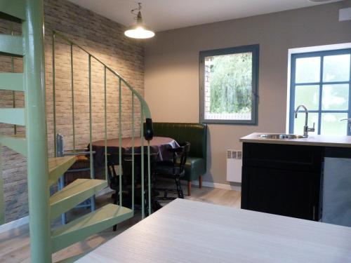 a kitchen and dining room with a table and a sink at 51 côté jardin in Selvigny